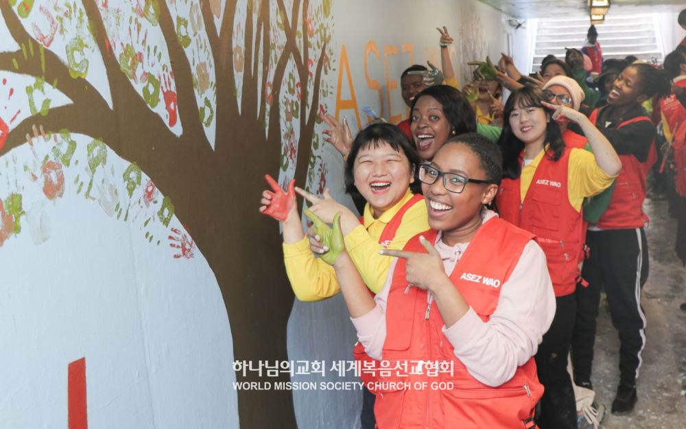 남아프리카공화국 케이프타운 크로포드역에 벽화를 그린 회원들이 환하게 웃고 있다.